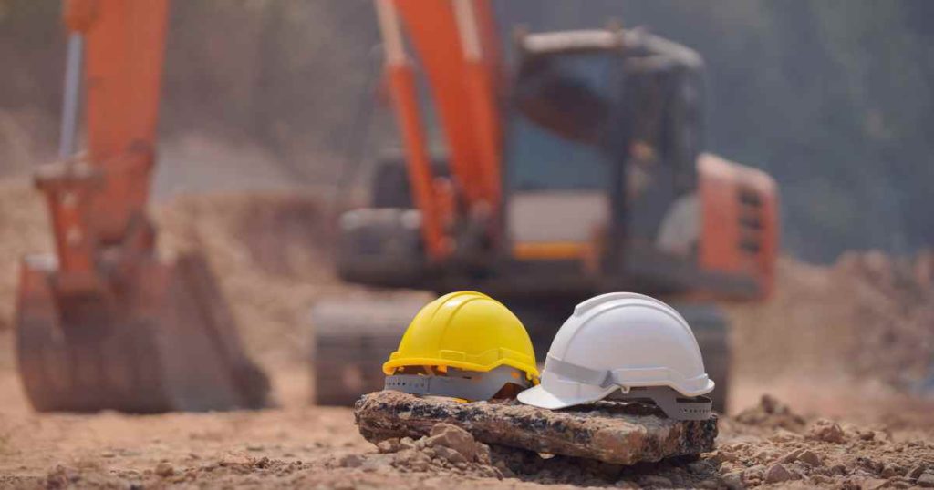 Construction site with excavator and safety hardhats